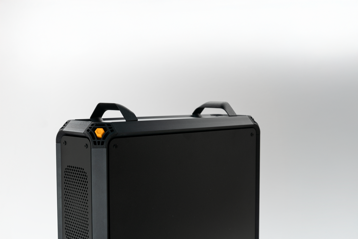Close-up of the Lucebox chassis top, carry handles and orange power button